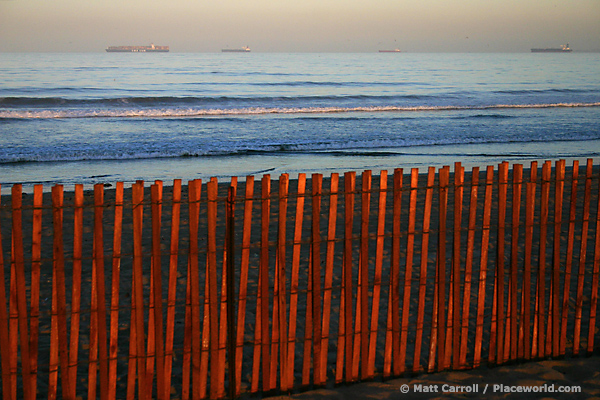fence and container ships at dawn