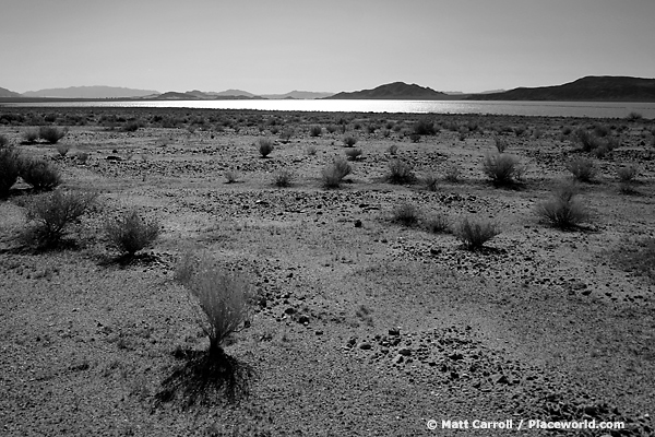 desert landscape with lake and mountains in distance