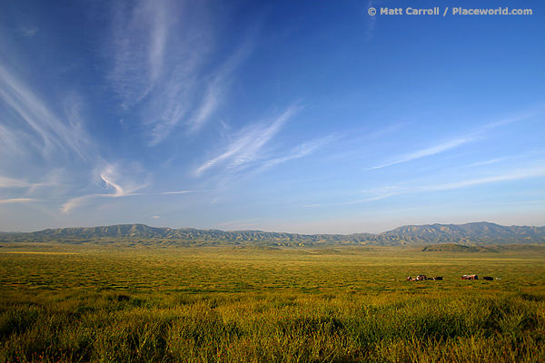 vast plain and sky with mountains between them